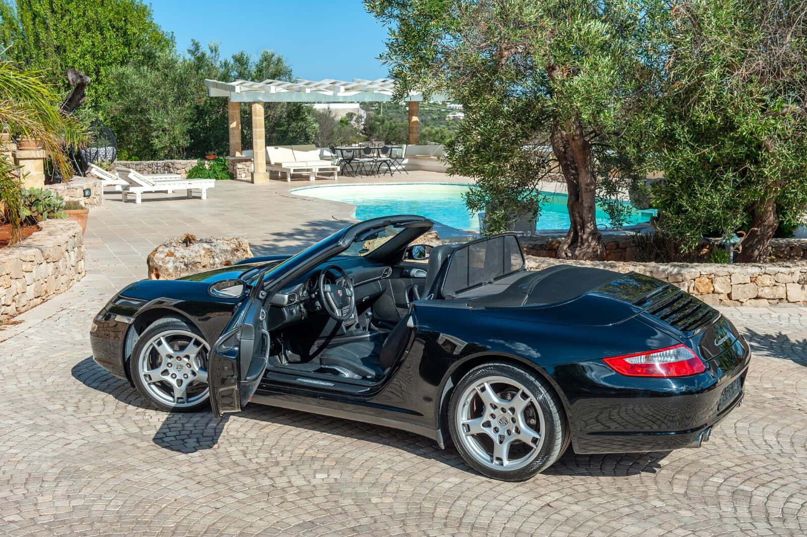 Porsche 911 Carrera 4 Cabriolet a bordo piscina, tra gli ulivi di una villa nel Salento Porsche 911 Carrera 4 Cabriolet a bordo piscina, tra gli ulivi di una villa nel Salento